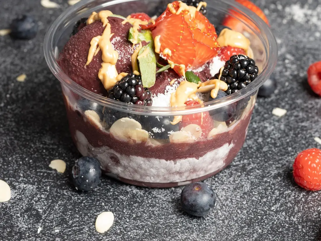 Açaí-Bowl im durchsichtigen Becher mit Früchten und Nüssen