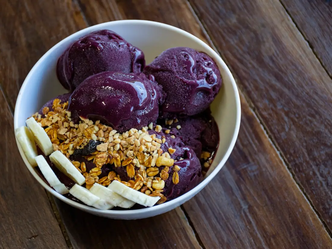 Açaí-Sorbet in Kugeln mit Banane und Granola in einer Schale