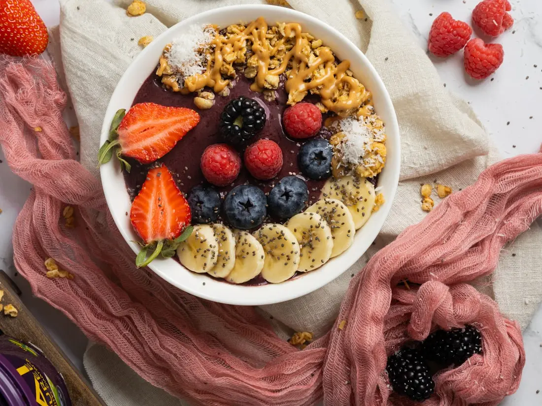 Açaí-Bowl mit Granola, Erdbeeren, Heidelbeeren und Bananenscheiben